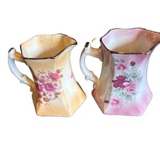 Rockingham pottery 2 jugs one has logo on bottom. One pink One pale orange gc