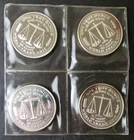 Four 1986 1oz Silver World Trade Unit Rounds in Plastic