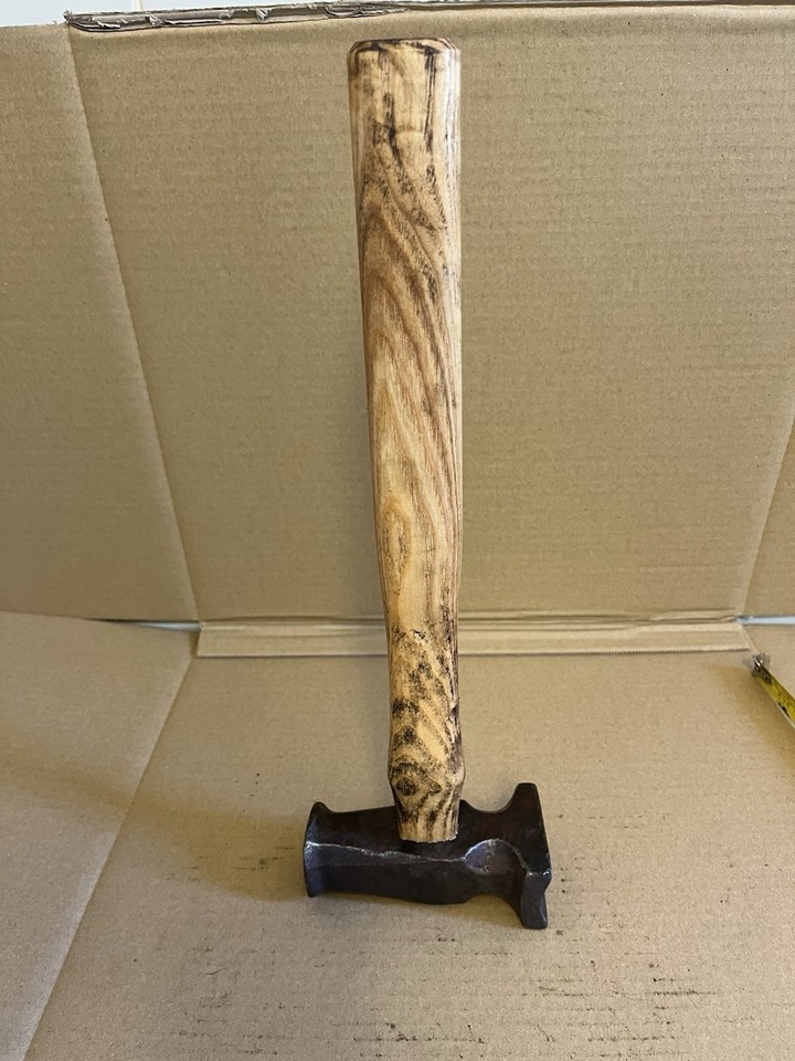 A 2.5lb blacksmith hammer with an unusual curved face — a working antique that doubles as a striking piece of industrial sculpture.