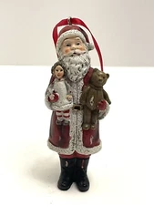 Melrose International Resin Santa Ornament Holding a doll and a Teddy Bear