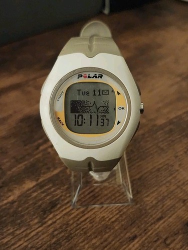 Beige vintage Polar F6 heart rate monitor with yellow-black display showing time 10:11:37 and Polar logo.