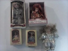  FOUR PORCELAIN DOLLS & ONE PLASTIC DOLL