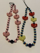 Two heart phone lariats pink and the other is red and yellow