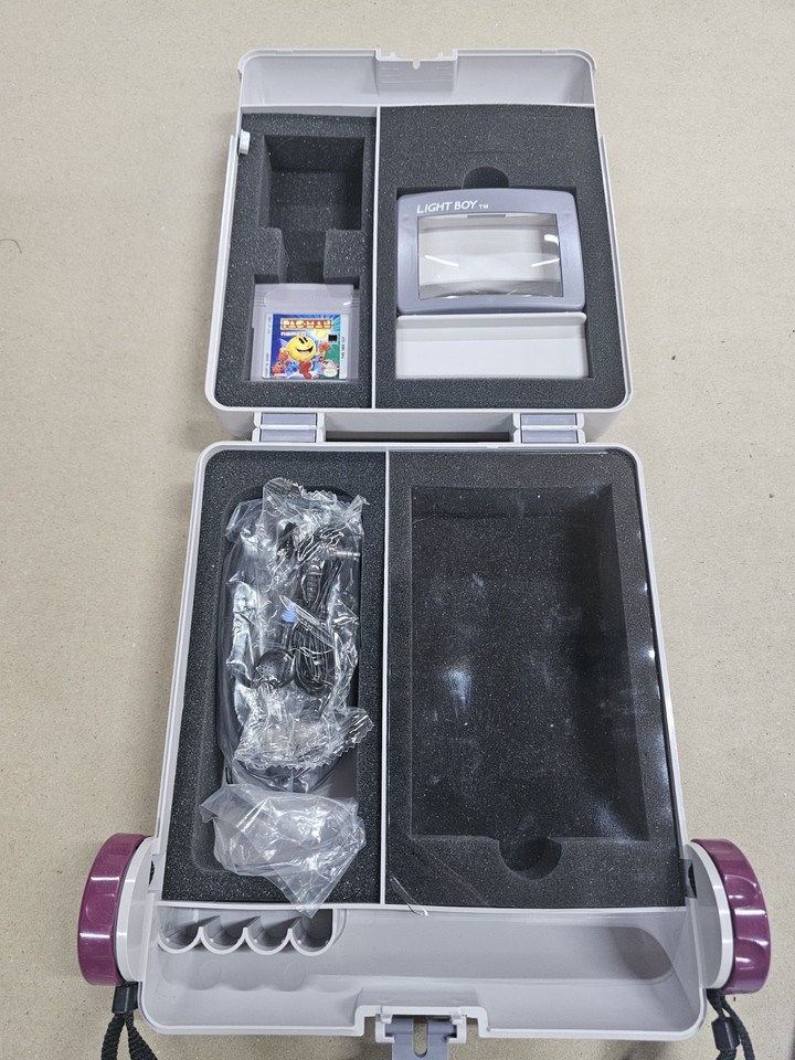 A rare Game Boy Light (Japan-only backlit model) paired with a vintage Game Keeper case and two games — this is the holy grail for any Game Boy collector.