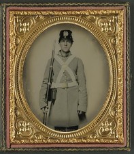 Photo:Unidentified soldier in Confederate uniform and kepi with musket