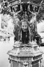Jean Bertola posando detrás de una fuente Wallace en París en octubre - Foto antigua