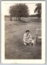 Vtg B&W Snapshot Woman In Floral Dress Crouching With Dog By Chair Farm 1940s