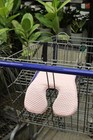 Pink gel polymer and memory foam car seat cushion with textured egg-shaped design, resting on a blue metal shopping cart.