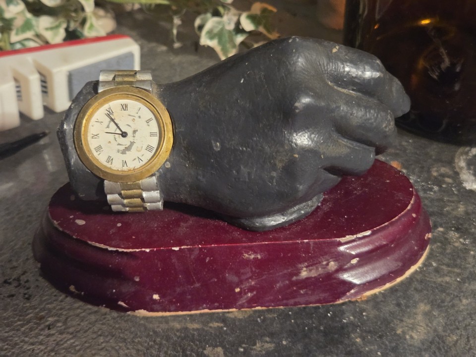 A bronze fist-shaped watch statue paperweight that doubles as a weird desk oddity — the 'for parts' condition only adds to its mysterious charm.