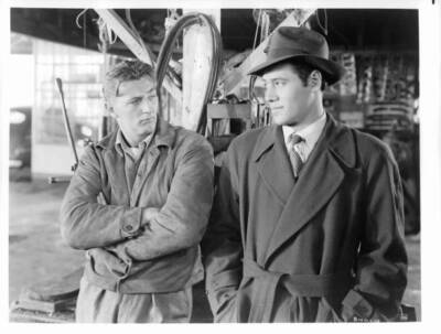 Robert Mitchum arms folded looking over Steve Brodie a scene film - Old Photo