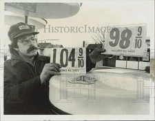 Press Photo Hal Vojik, gas station manager holding up gas prices. - sra38723