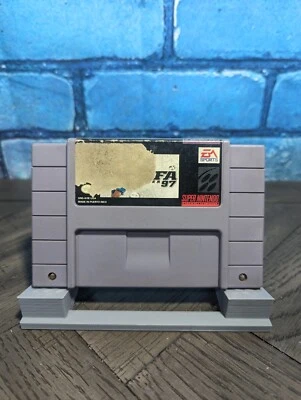 Gray Nintendo Super Famicom cartridge with black and white label reading “FIFA Soccer 97” and “EA Sports” in gold block letters.