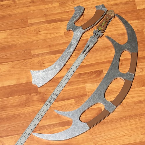 Klingon Bat’leth, Mek’Leth, and Dak’Tang dagger cosplay props with silver blades and brown accents on wooden floor.