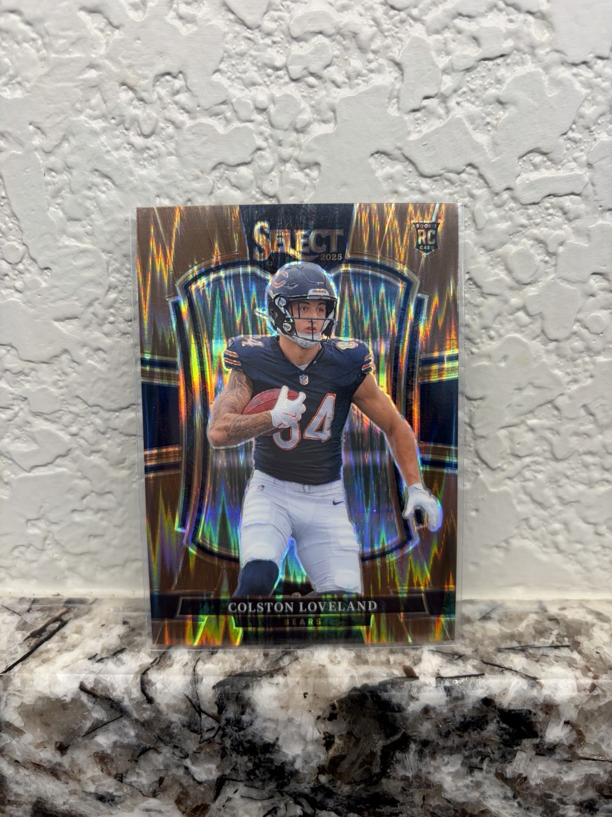 2025 Select Football Colston Loveland Copper Prizm Shock /899 Premier Level (RC)