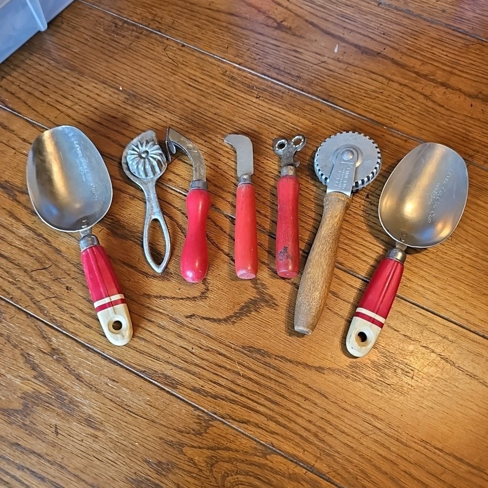 A matched set of 7 mid-century red wooden handle utensils that look straight out of a 1950s farmhouse kitchen — instant retro styling as a display or everyday use set.