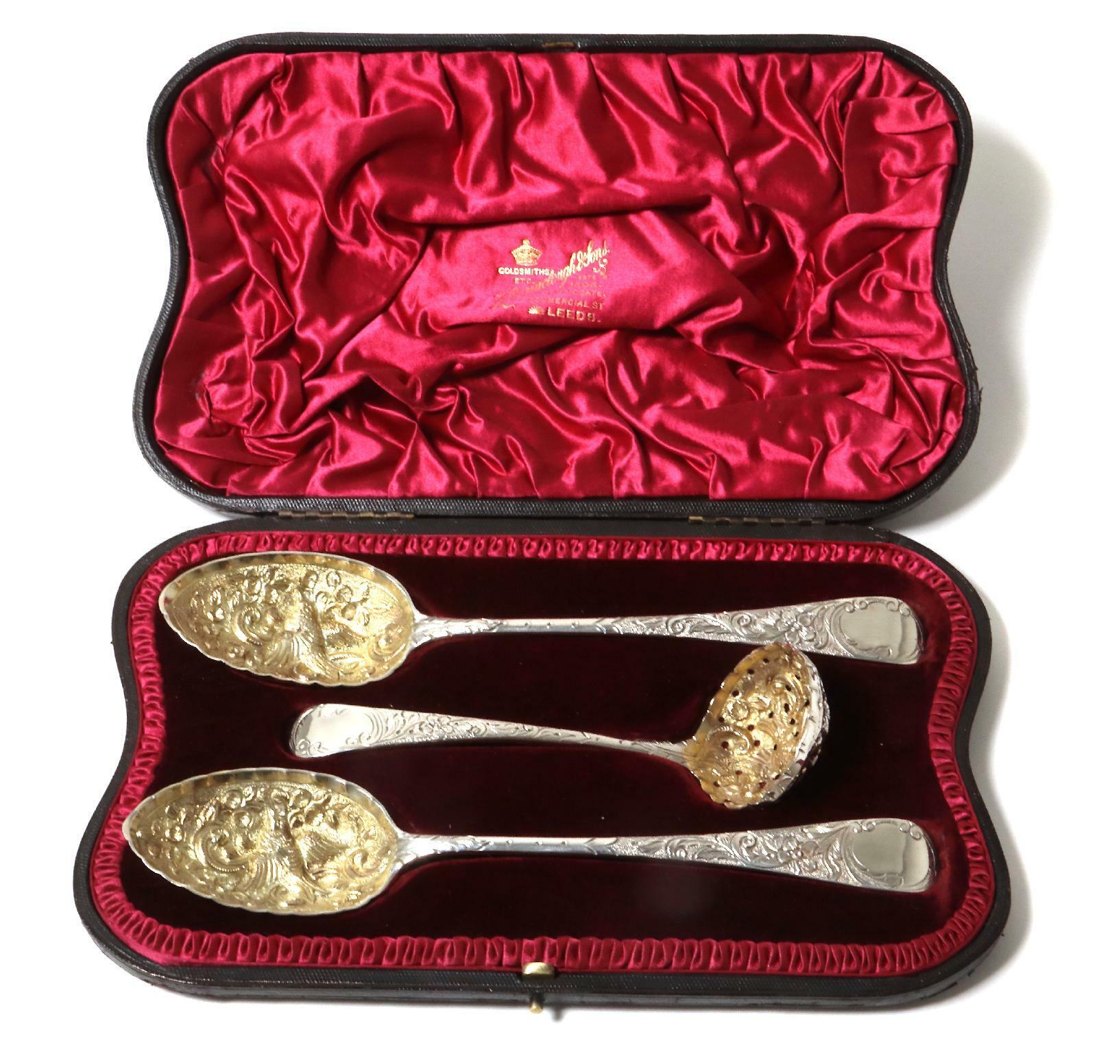 Silver serving set of three items: two spoons and small ladle-strainer. England.
