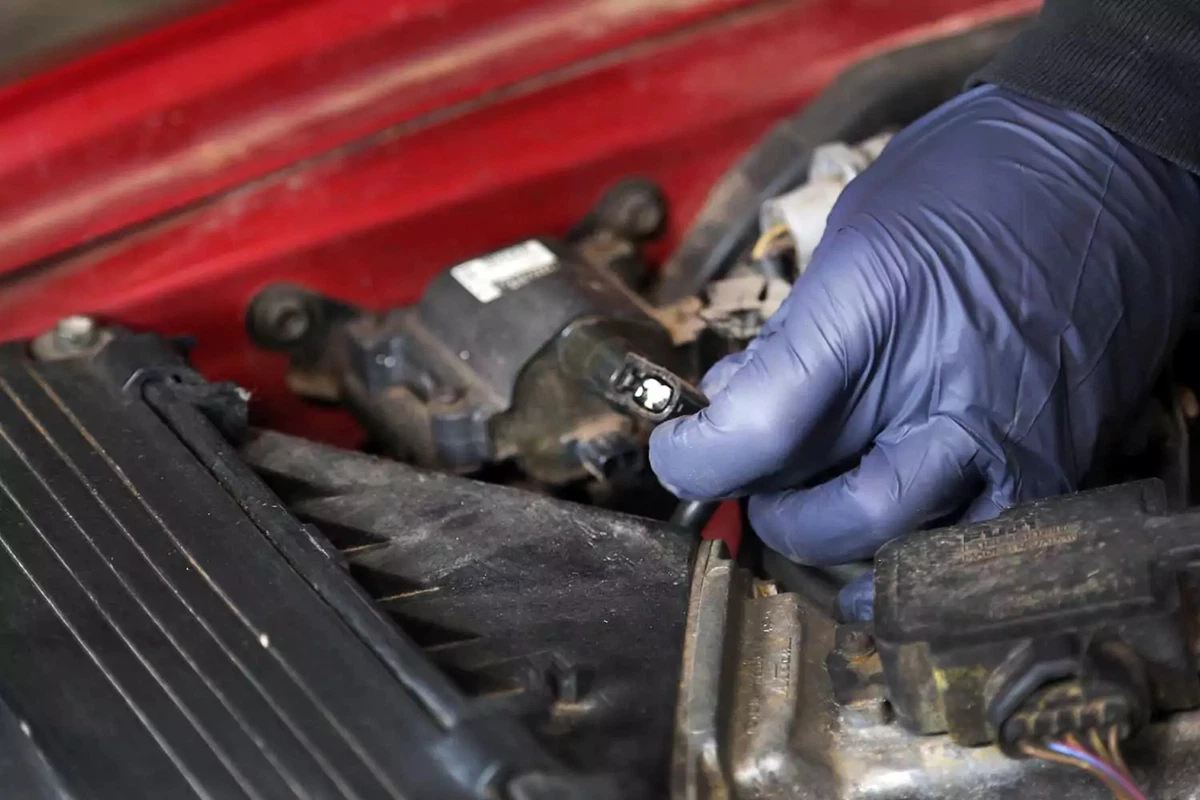 Holding an ignition coil wiring plug.
