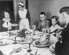 Father carves turkey while maid serves a family dinner party Old Photo