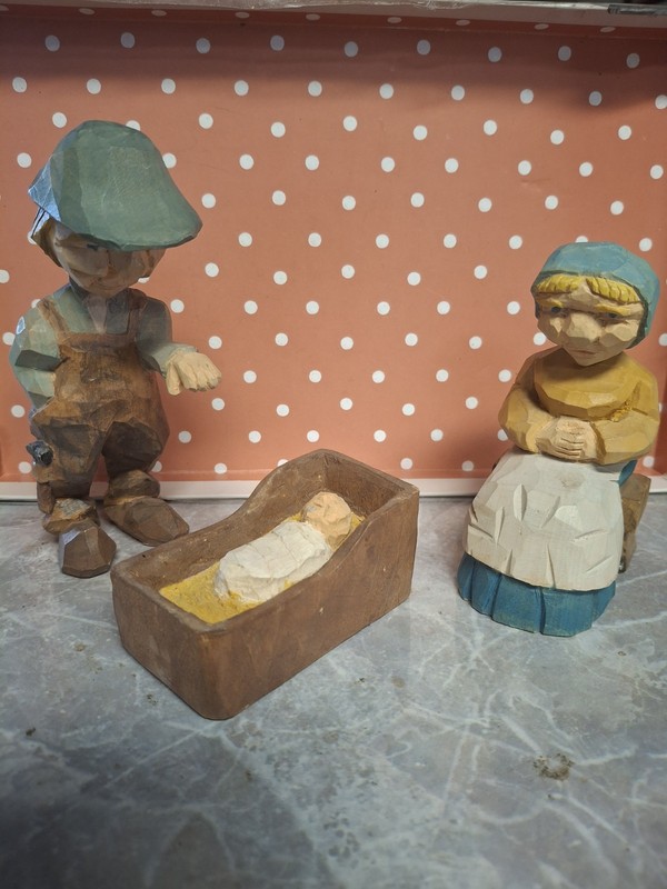 3 Hand Carved Wooden Figures  Man In Bibs Lady On Bench & Infant In Cradle