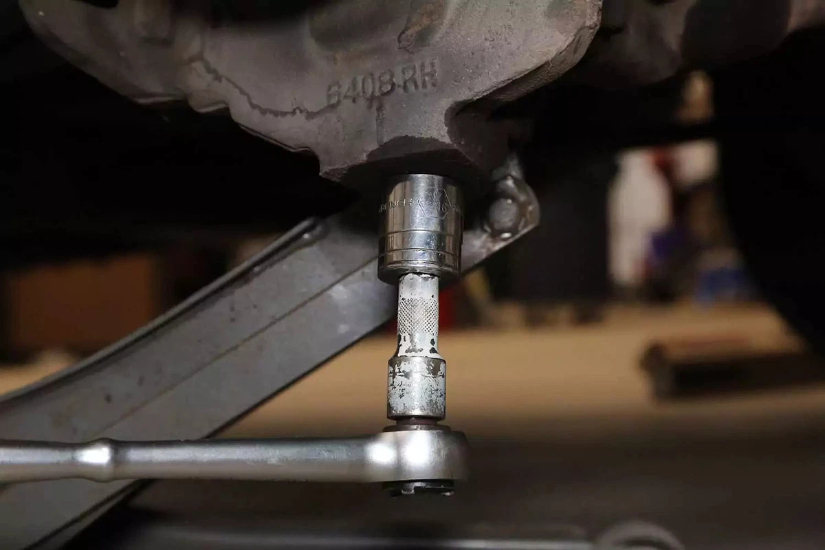 A mechanic removes the castle nut with a socket and ratchet.