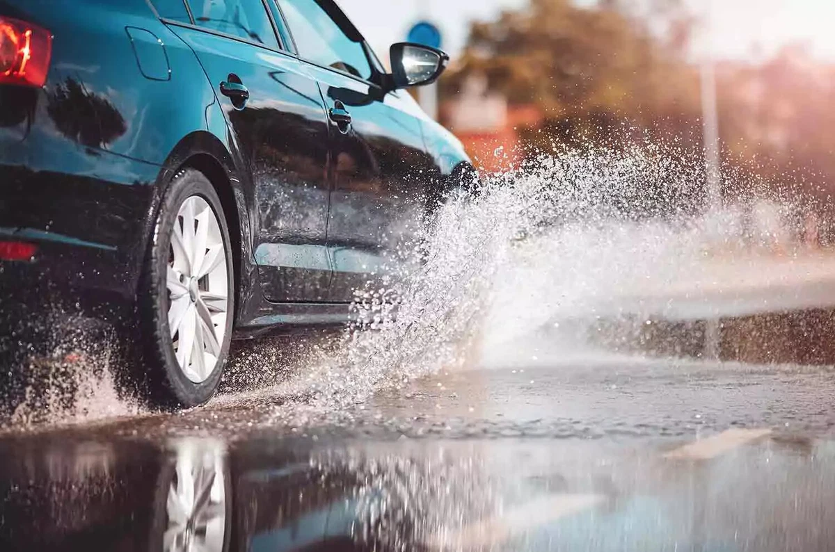 A car driving through a puddle of water.