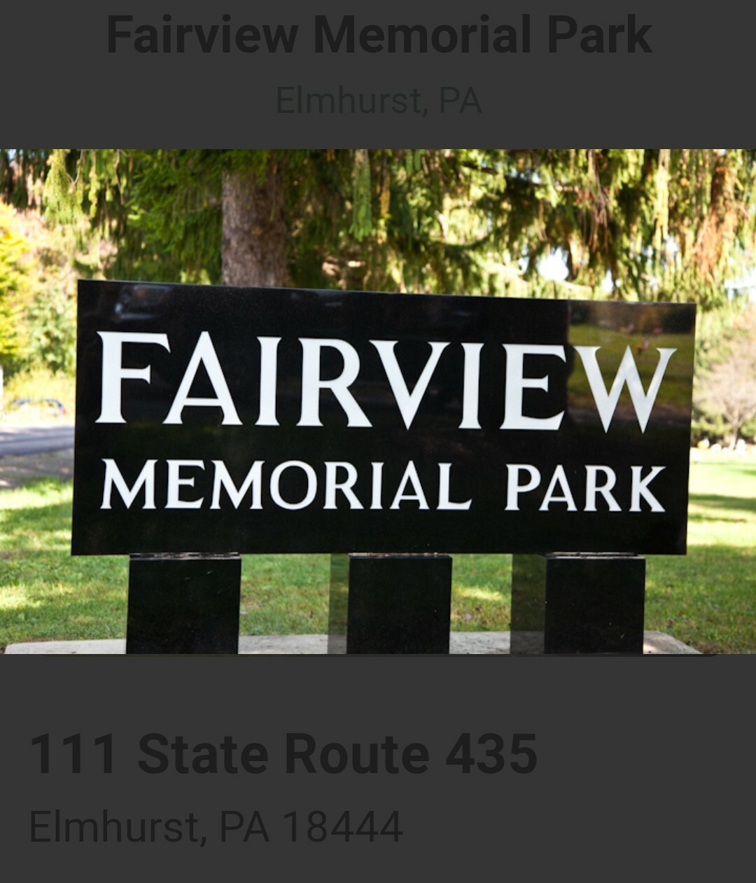 Black granite mausoleum crypt with bronze plaque reading “FAIRVIEW MEMORIAL PARK” on three square bases in a grassy area.