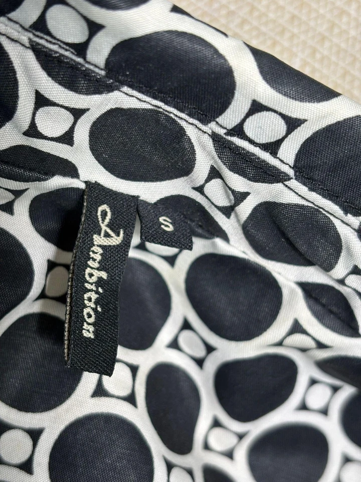 Gabardina Ambition para mujer pequeña negra blanca con cinturón manga corta estampado circular Foto 3 de 4