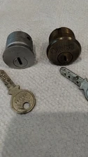 2 KABA 15/16TH Mortise cylinders, Alum fin. has 1 key, Ant. Brass has 4 keys.