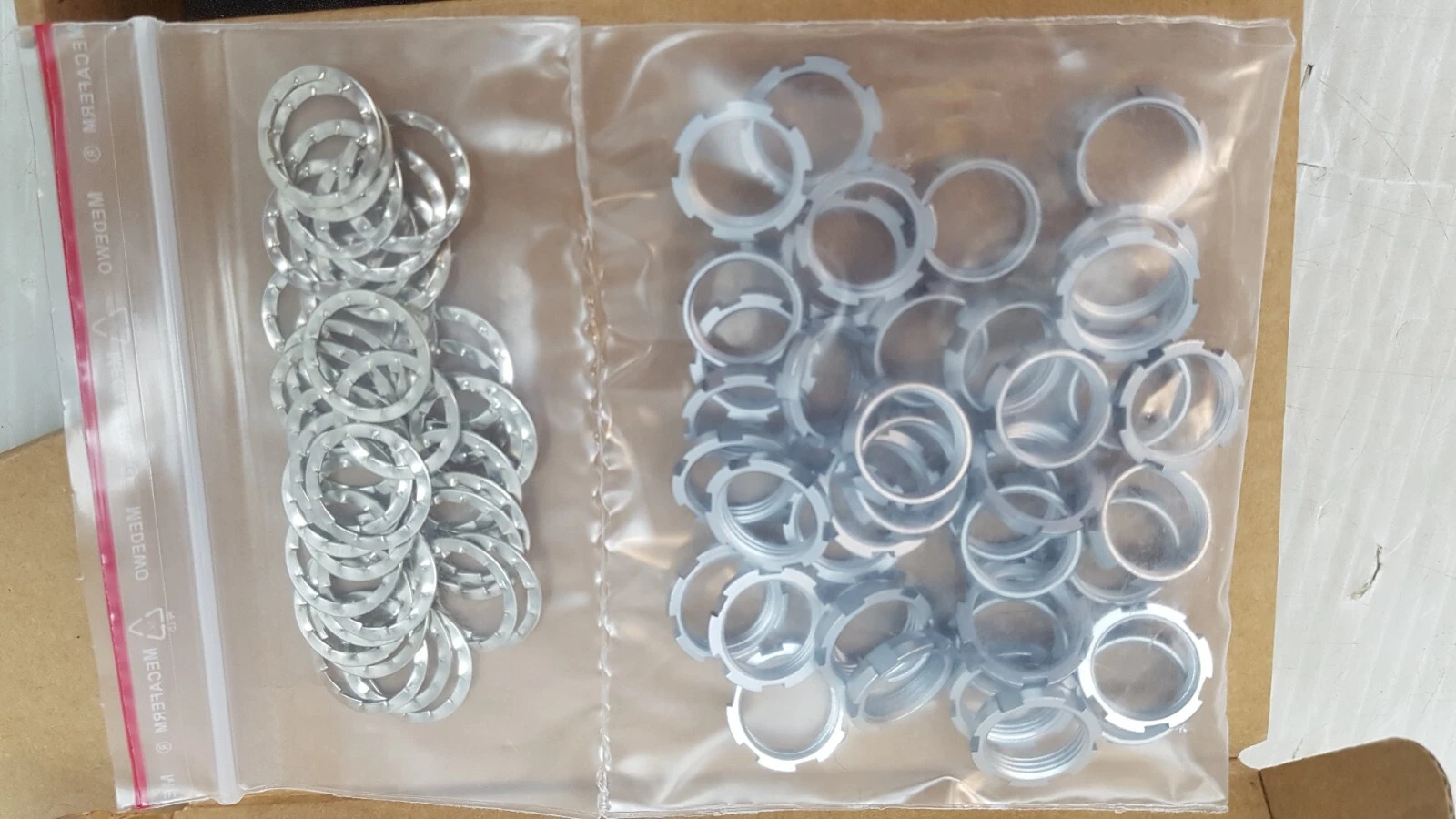 Two zip bags of toothed lock washers and slotted panel nuts for ODU MINI-SNAP receptacles