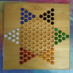 wooden chinese checkers board with marbles