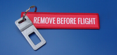 Anhänger REMOVE BEFORE FLIGHT mit Gurtzungen Dummy