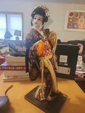 vintage Japanese Geisha doll wearing a detailed silk brocade kimono.
