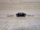 Black plastic Fanuc A08B-0088-K050 connector housing with two silver metal pins on a light wood surface.