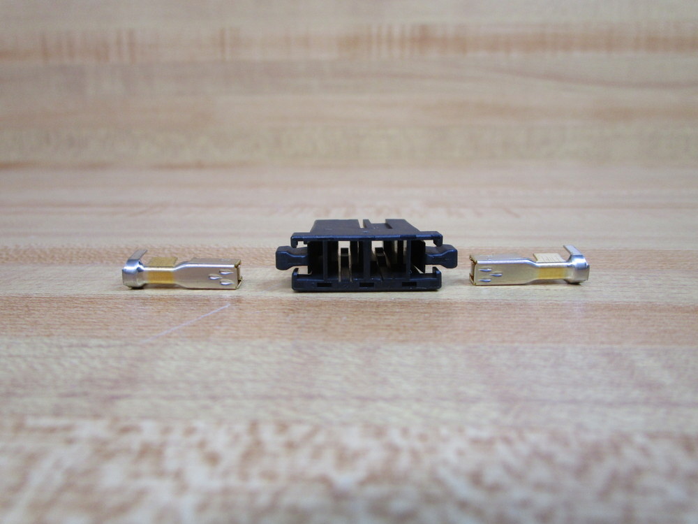Black plastic Fanuc A08B-0088-K050 connector housing with two silver metal pins on a light wood surface.