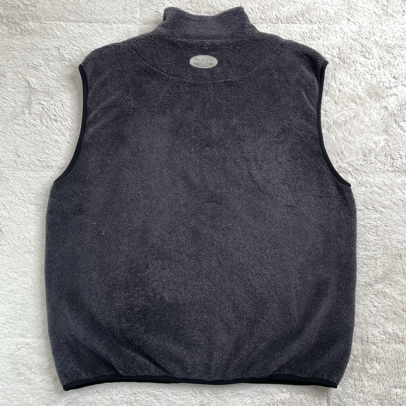 Dark gray Polartec fleece golf vest with high collar, front zipper, and small white logo on left chest.