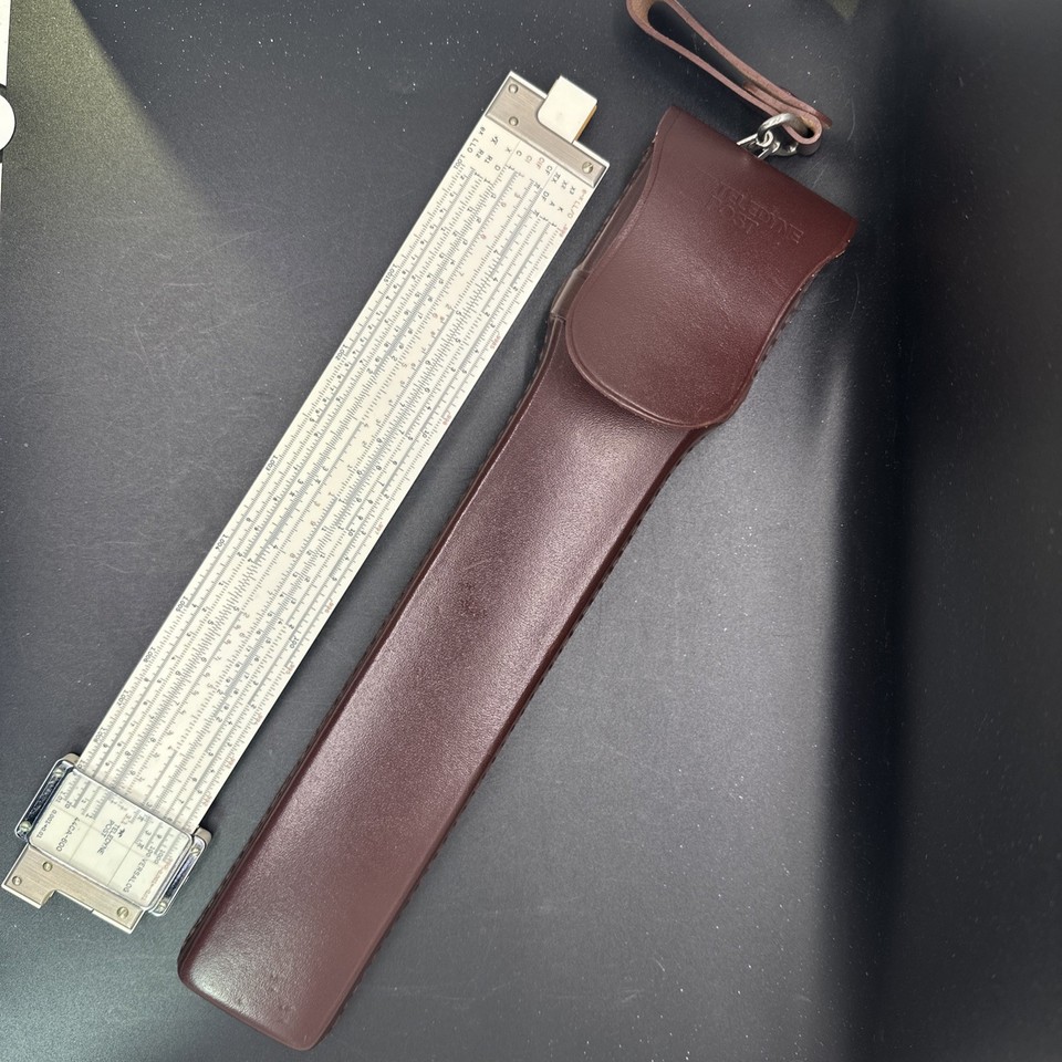 A Teledyne Post log-log slide rule with original leather case — a premium-brand piece of analog computing history with serious desk presence.