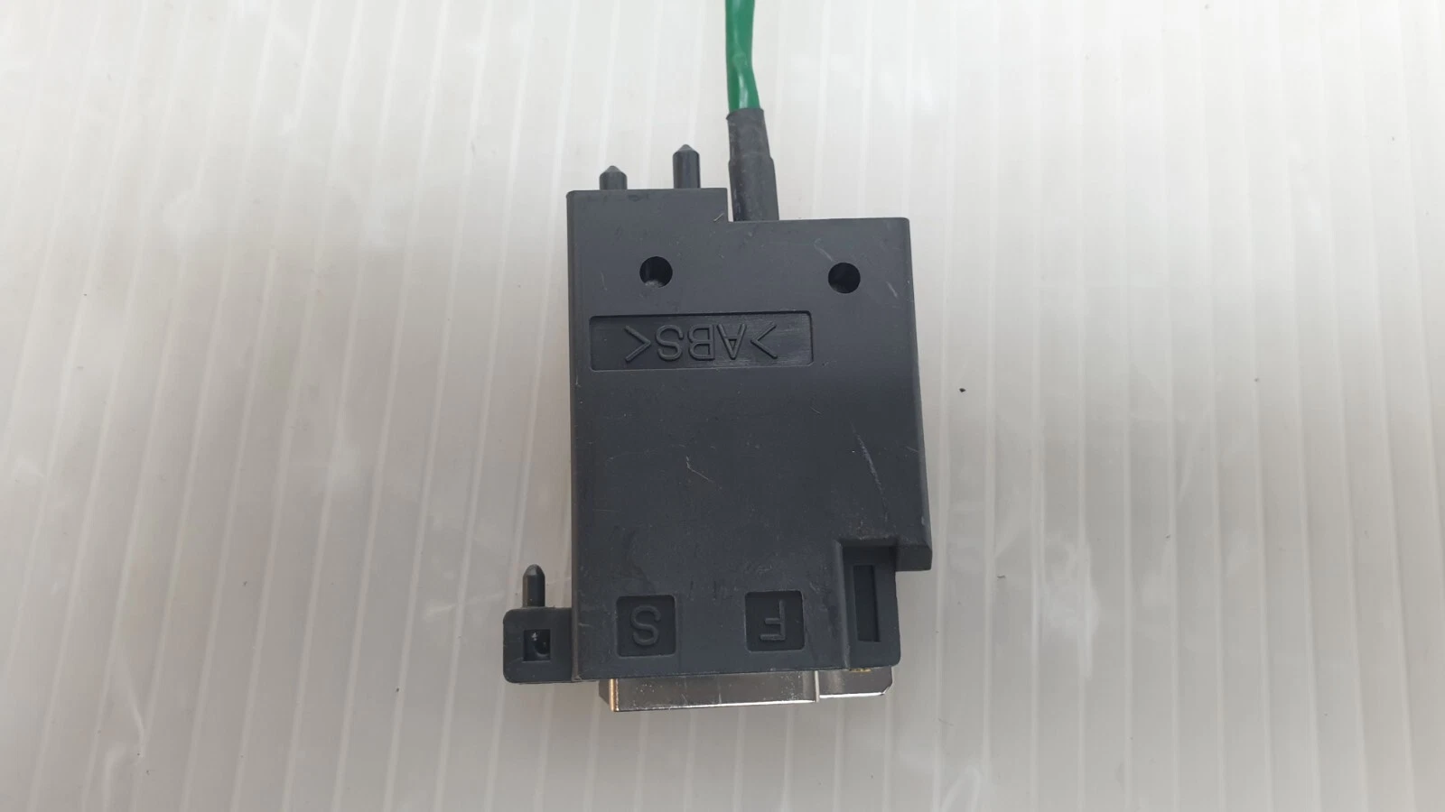 Connector housing marked ABS with S and F markings, green lead entering
