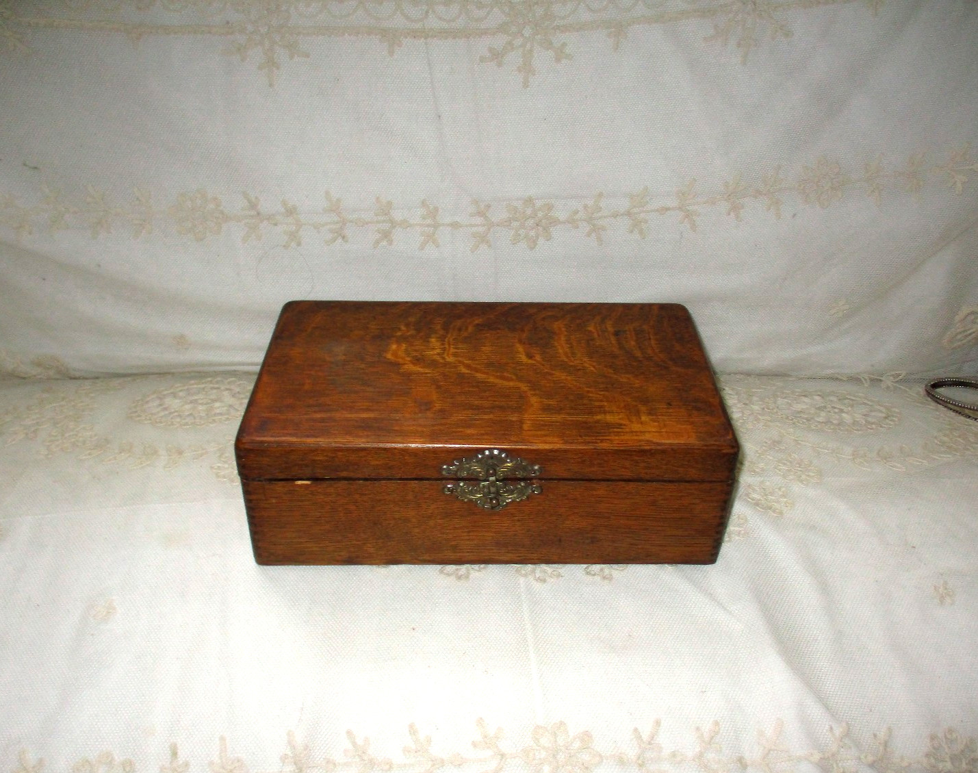 Antique tiger oak jewelry and keepsake box with brass clasp.