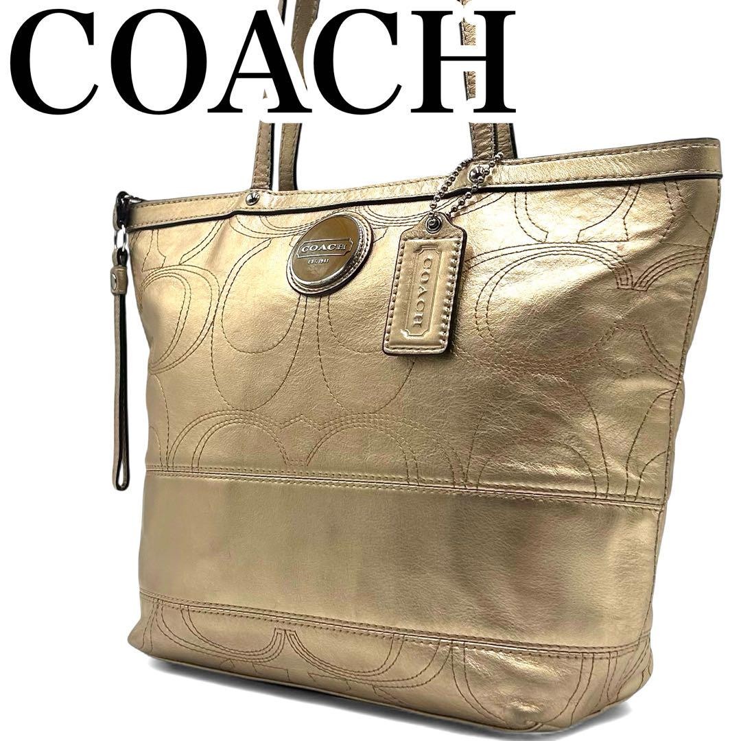 Coach handbag in excellent condition featuring signature gold logo and charm