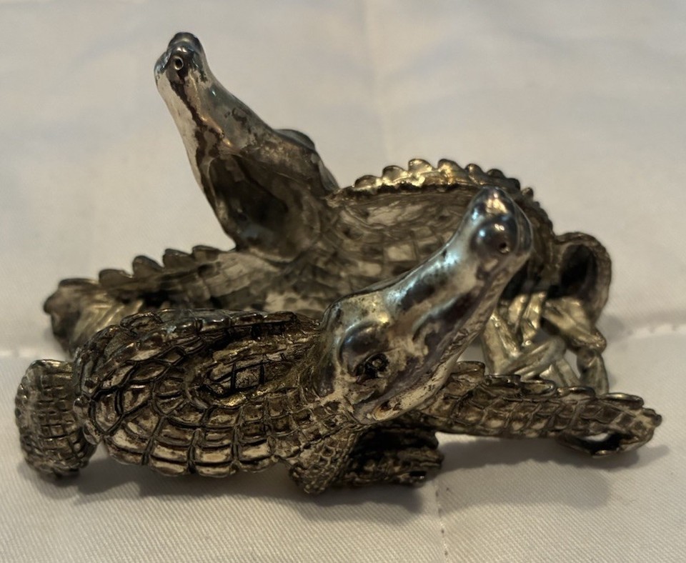 A heavy silver metal alligator-shaped business card holder that moonlights as a paperweight — equal parts gothic and professional.