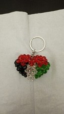 A medal in the shape of a heart and the Palestinian flag, handmade from beads
