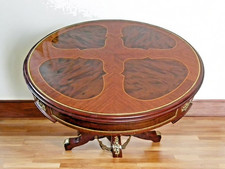 Une table ronde style Louis XV en bois hêtre marron et bronze doré avec motifs
