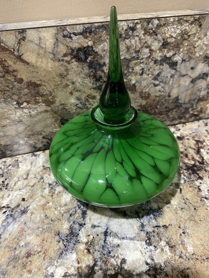 Emerald green art glass perfume decanter with swirl designs — it straddles the line between barware and art object in the best way.