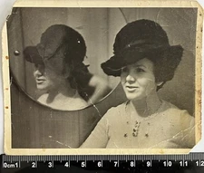 Young beautiful woman in a hat, reflection in the mirror, unusual old photo
