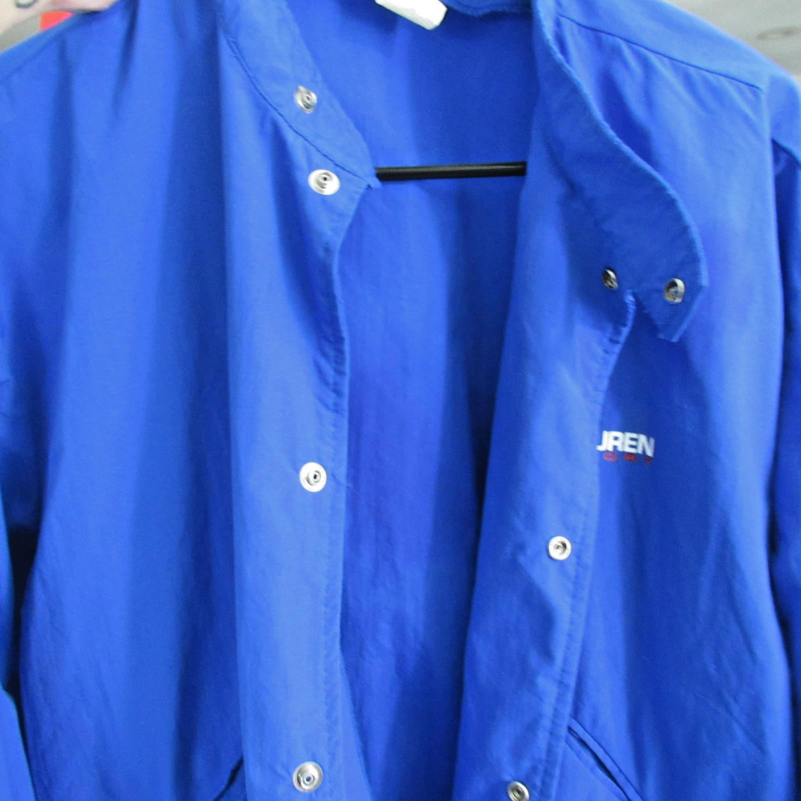 Blue vintage 90s Polo Sport Ralph Lauren jacket with white snap buttons, pointed collar, and small white “JREN” logo on chest.