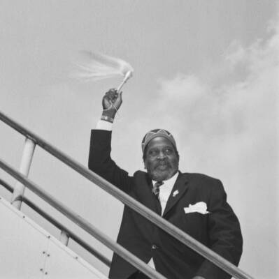 Jomo Kenyatta waves his fly whisk as he leaves London Airport 1960s OLD PHOTO