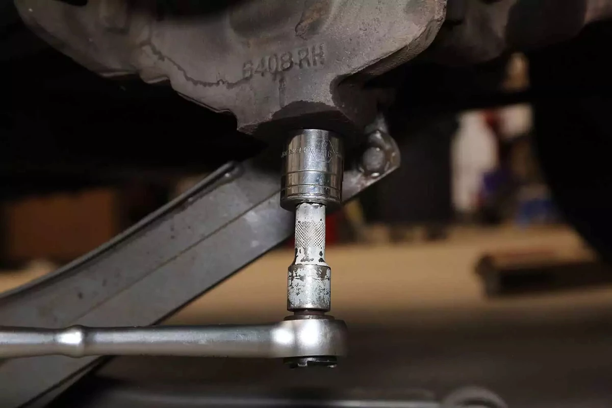 A mechanic removes the castle nut with a socket and ratchet.