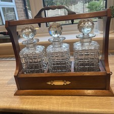 Antique Victorian vintage wooden tantalus with 3 decanters & brass fittings.