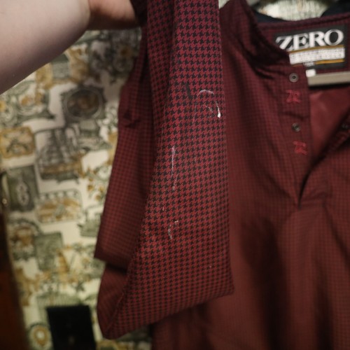 VTG Zero Restriction men’s golf jacket with maroon and black houndstooth pattern, button placket, and front pockets.