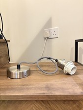 Chrome light fixture with black and white cord, hanging light. 